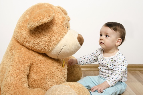 Bambino guarda peluche