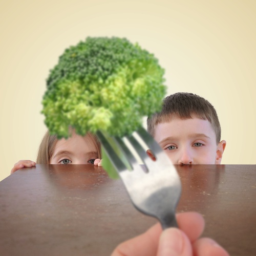 Bambino mangia broccoli.
