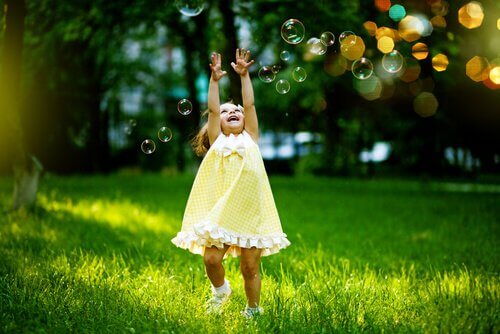 Bambina felice con bolle di sapone