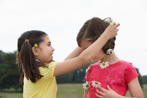bambina-regala-collana-di-fiori-ad-amica