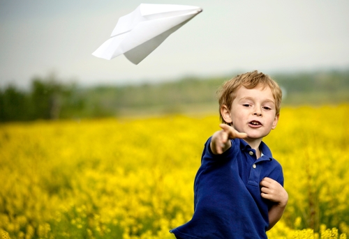 bambino-gioca-con-aeroplanino-di-carta