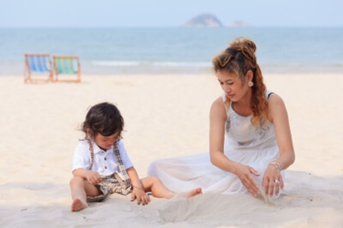 mamma single gioca-con-bambino-in-spiaggia
