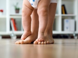 Aiutare un bambino a camminare facendolo con lui