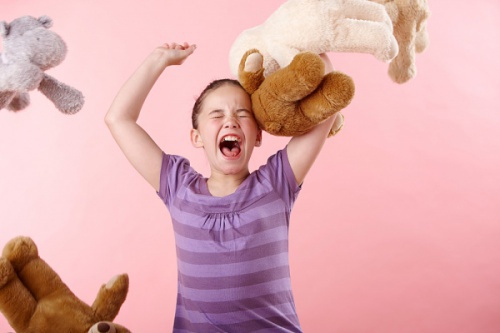 bambina-arrabbiata-lancia-i-peluche