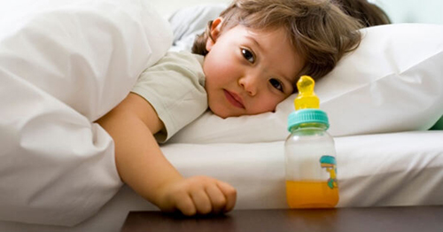 bambino-con-biberon-sul-comodino