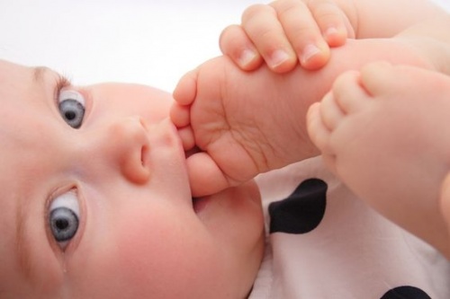 Neonato con il piede in bocca