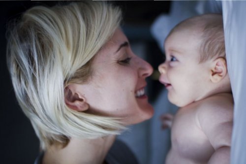 Una mamma coccola il suo neonato.