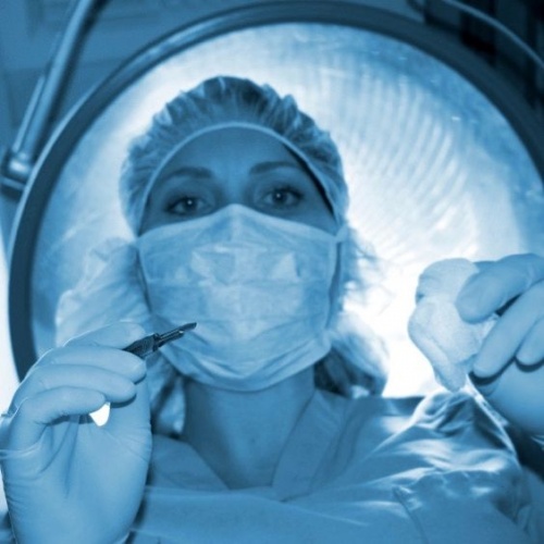 Ostetrica con bisturi durante un parto cesareo