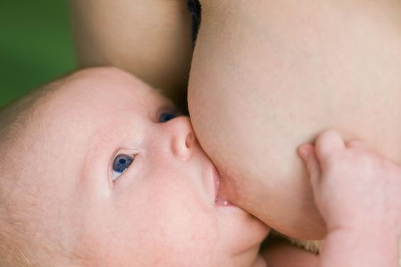 Primi giorni a casa con un neonato: una mamma allatta al seno.