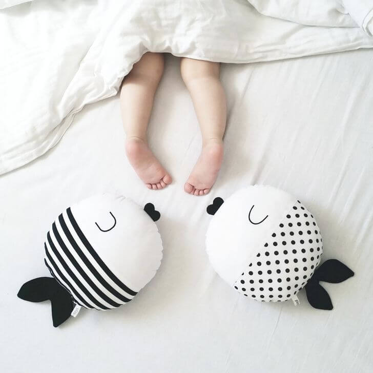 Il bambino si scopre mentre dorme, mettendo i piedi fuori dal letto.