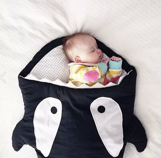 Neonato sotto le coperte con un pigiama caldo.