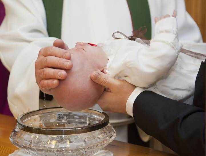 I padrini partecipano al rito del battesimo.