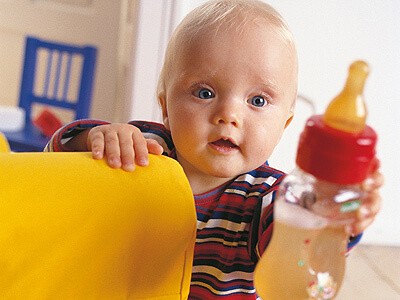 Un bambino tiene in mano il suo biberon