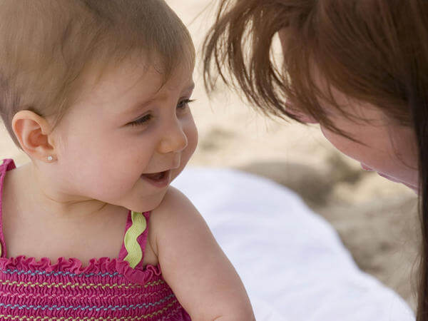 Bambina che sorride e guarda la mamma.