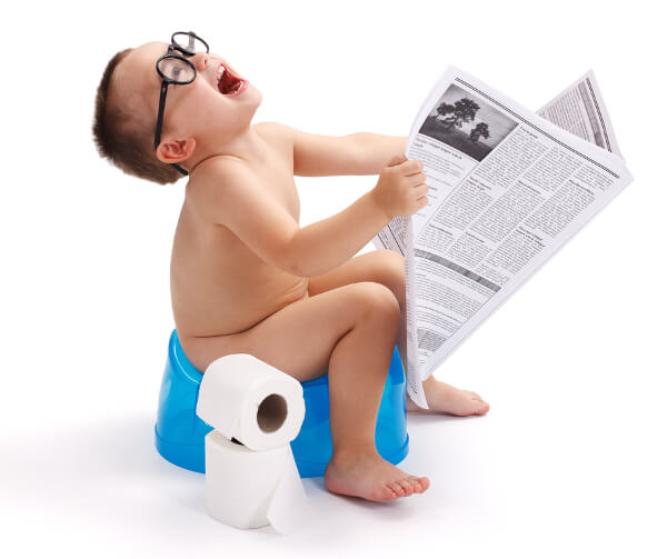 Bimbo sul vasino legge il giornale.