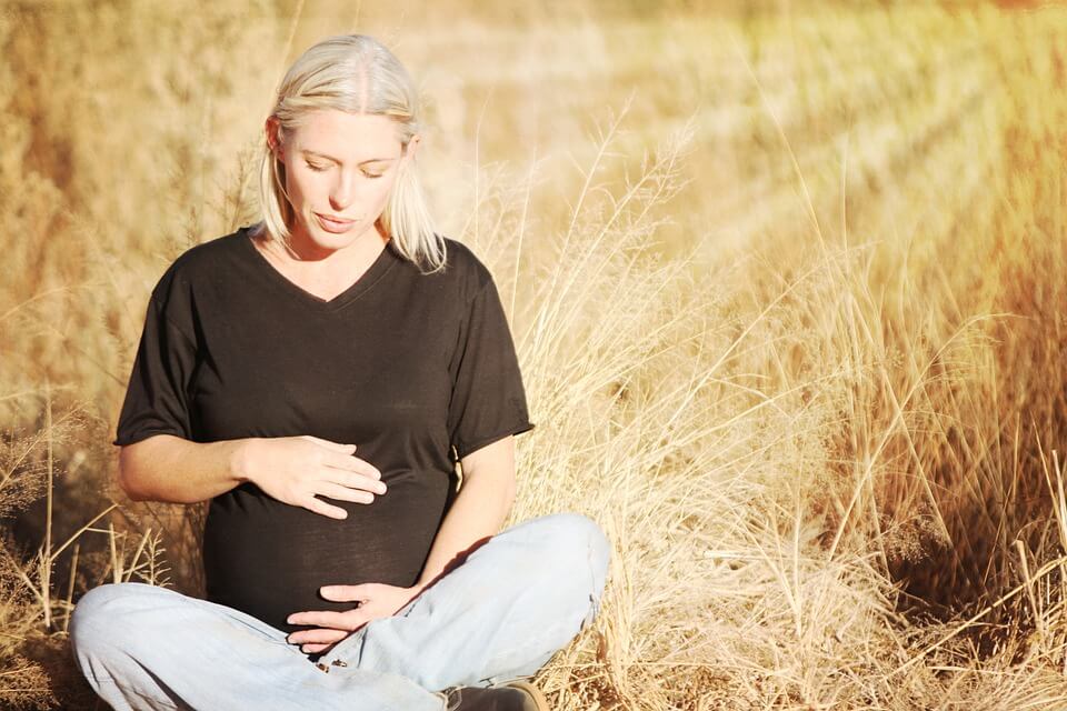 Diventare madre dopo i 40 anni: una donna incinta in un campo di grano.