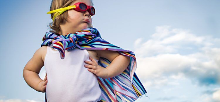 Bambino con accappatoio e occhialini in spiaggia.