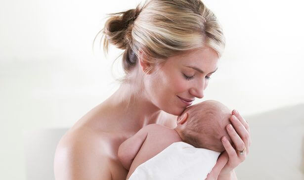mamma abbraccia e annusa neonato