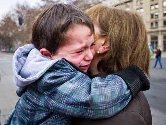 Non partire senza salutare il bambino: un bimbo piange abbracciato alla mamma.