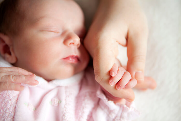 neonato tiene la mano