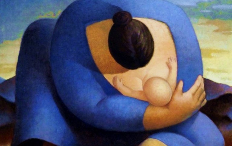 Madre allatta il figlio stringendolo in un abbraccio.