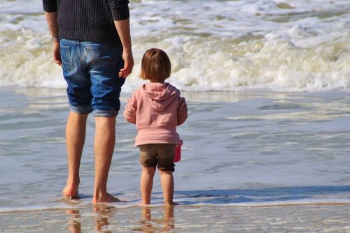 Segnali d'affetto: bimba al mare con il padre.