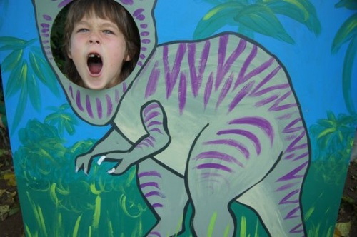 Bambino dietro figura di dinosauro