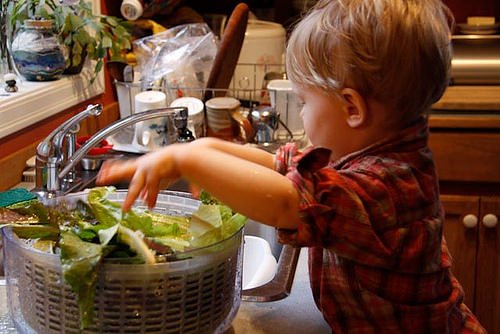 Un bimbo lava l'insalata.