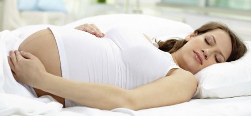 La posizione per dormire in gravidanza: donna sdraiata sul fianco sinistro.