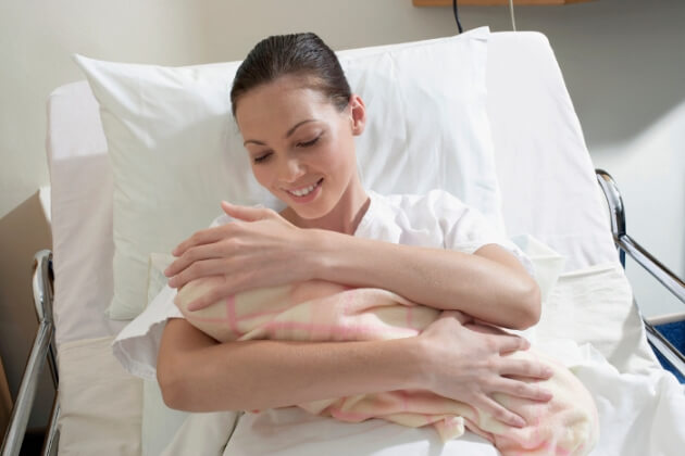 Una mamma stringe il neonato dopo il parto.