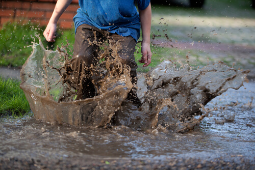 bambino che gioca nel fango