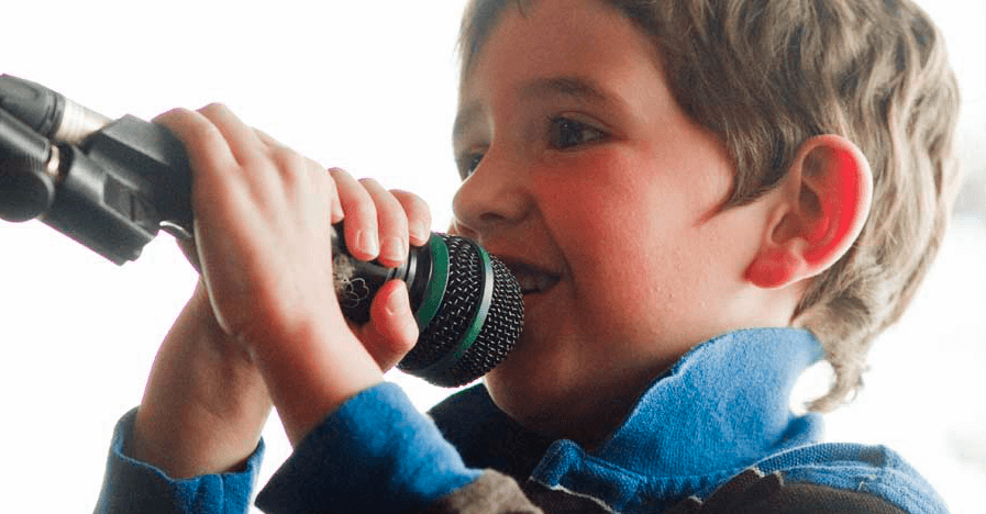 Bambino canta con un microfono