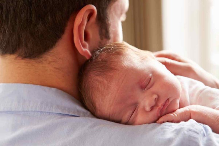 Papà che tiene in braccio un neonato