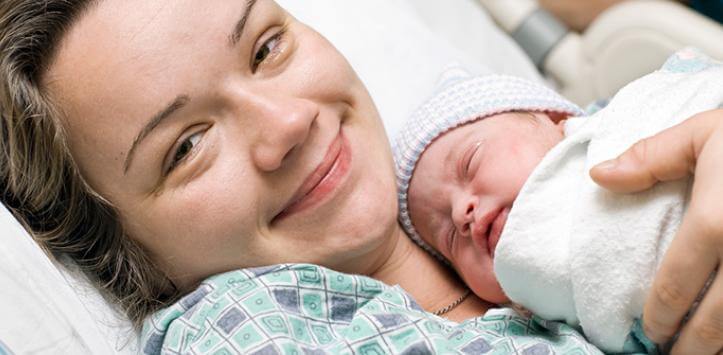 Madre sorride con il figlio in braccio