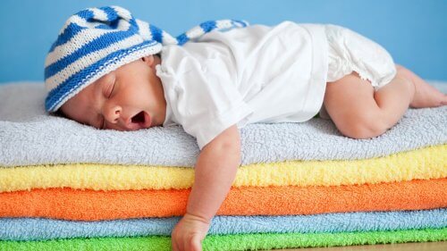 Neonato dorme su una pila di asciugamani