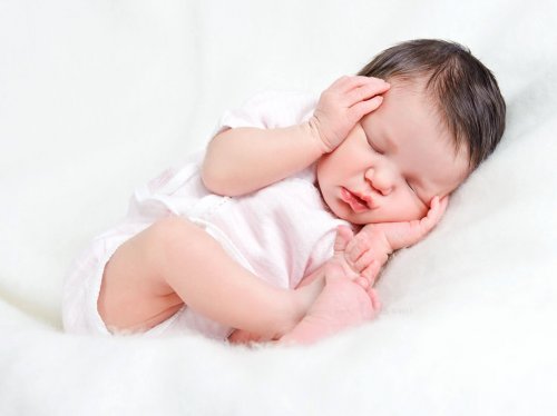 Neonato che dorme in posizione fetale