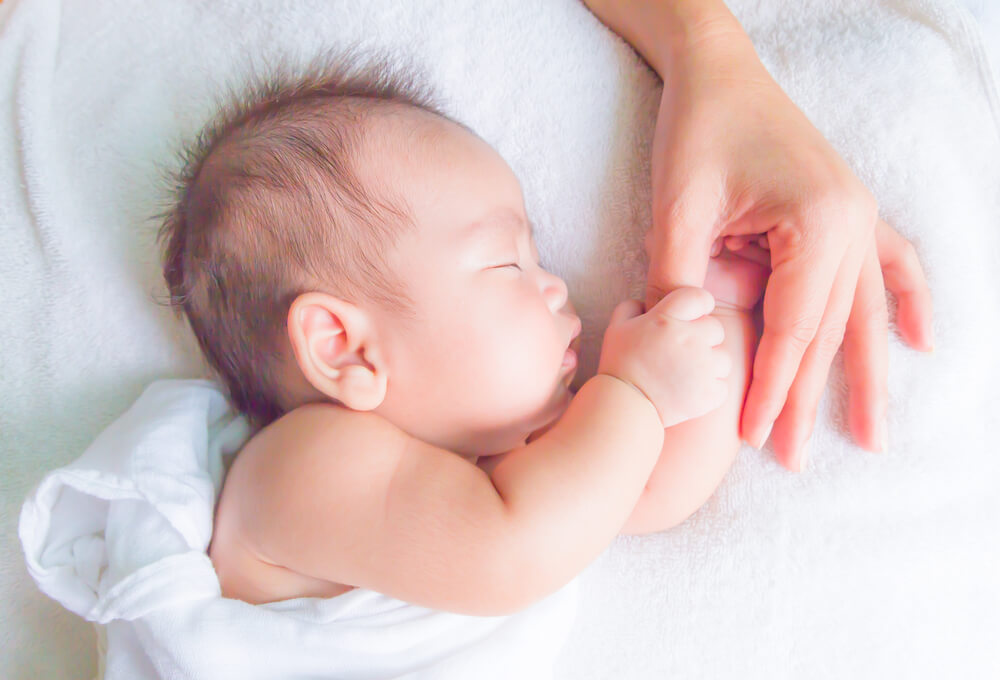 Neonato che dorme con la mamma