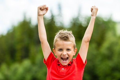 Bambino felice che esulta con le braccia alzate