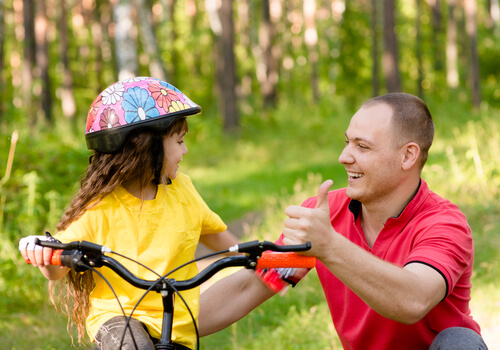 Papà insegna alla figlia ad andare in bicicletta