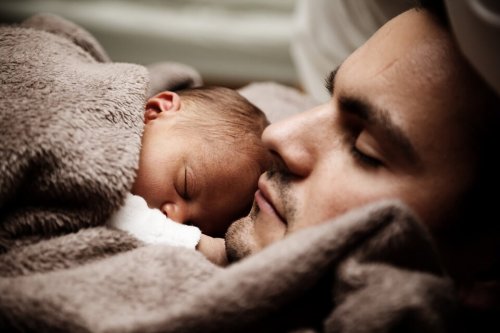 Neonato che dorme sul padre