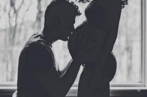 Uomo che bacia la pancia della compagna incinta