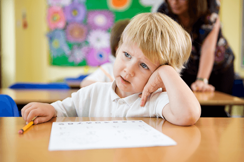 Bambino distratto durante la lezione a scuola