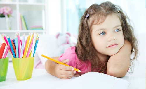 Bambina si distrae mentre fa i compiti