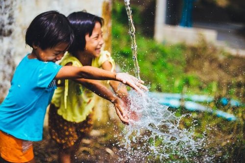 Bambini estroversi che giocano con l'acqua