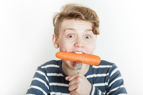 Adolescente che mangia una carota