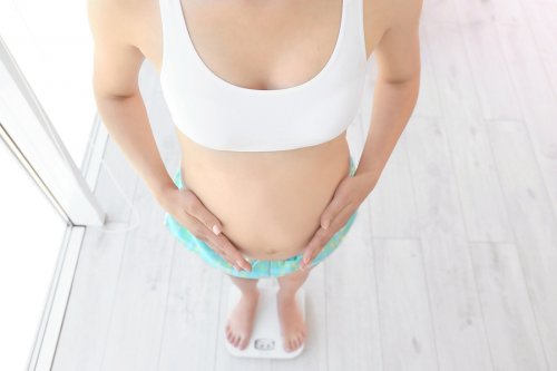 Donna in gravidanza si pesa sulla bilancia