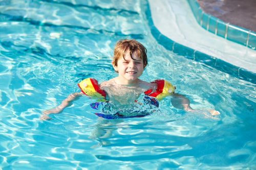 Bambino in piscina con i braccioli