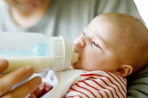 Neonato prende il latte dal biberon