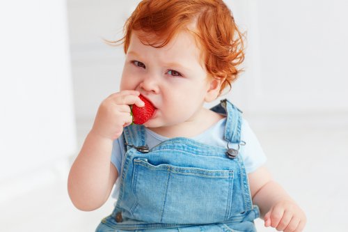 Bambino che mangia una fragola
