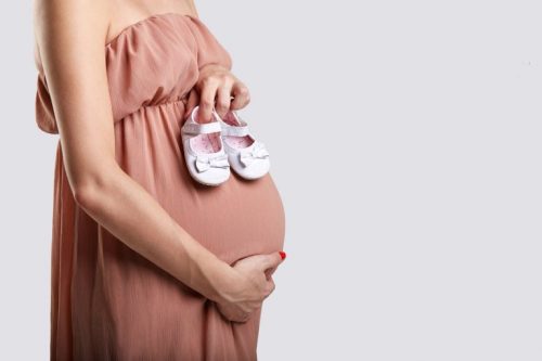 Donna incinta con un vestito senza spalline